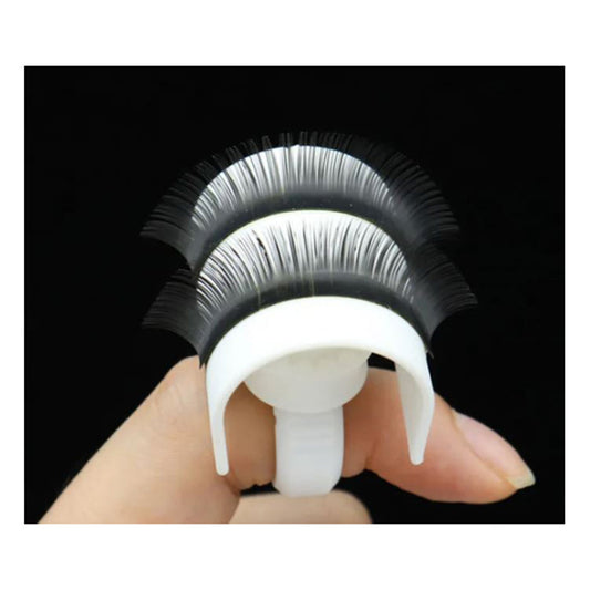 A hand holding a white lash ring and lash holder with multiple eyelashes attached to it.