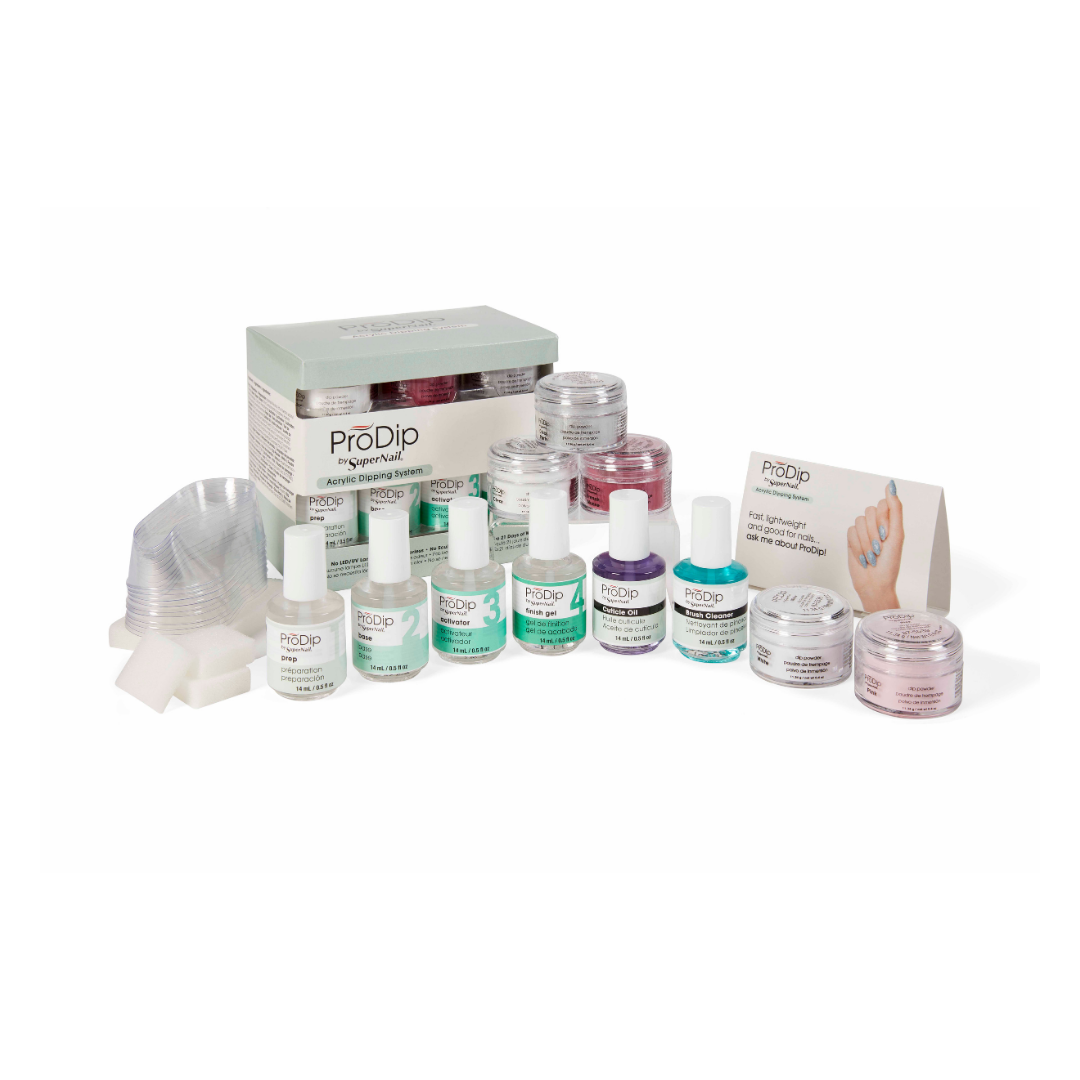 A ProDip nail dip powder kit arranged on a white background, including multiple bottles of different prep and topcoats, colored dip acrylic powder, jars with French acrylic colours, a stack of clear dipping bowls, a box, an instruction card, and a small hand sample card.
