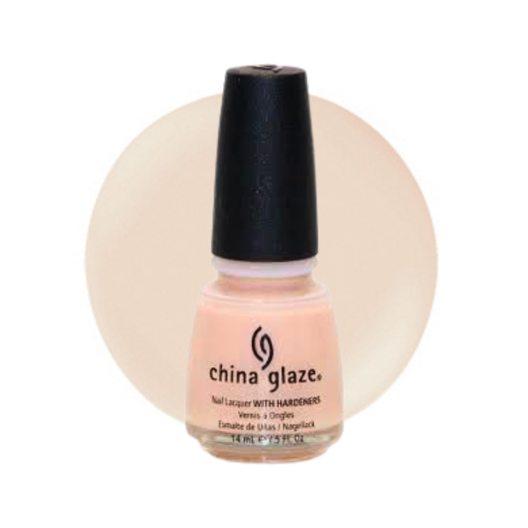 A bottle of China Glaze nail polish in a light peach-pink shade, featuring a black cap and a circular beige swatch behind it on a white background.