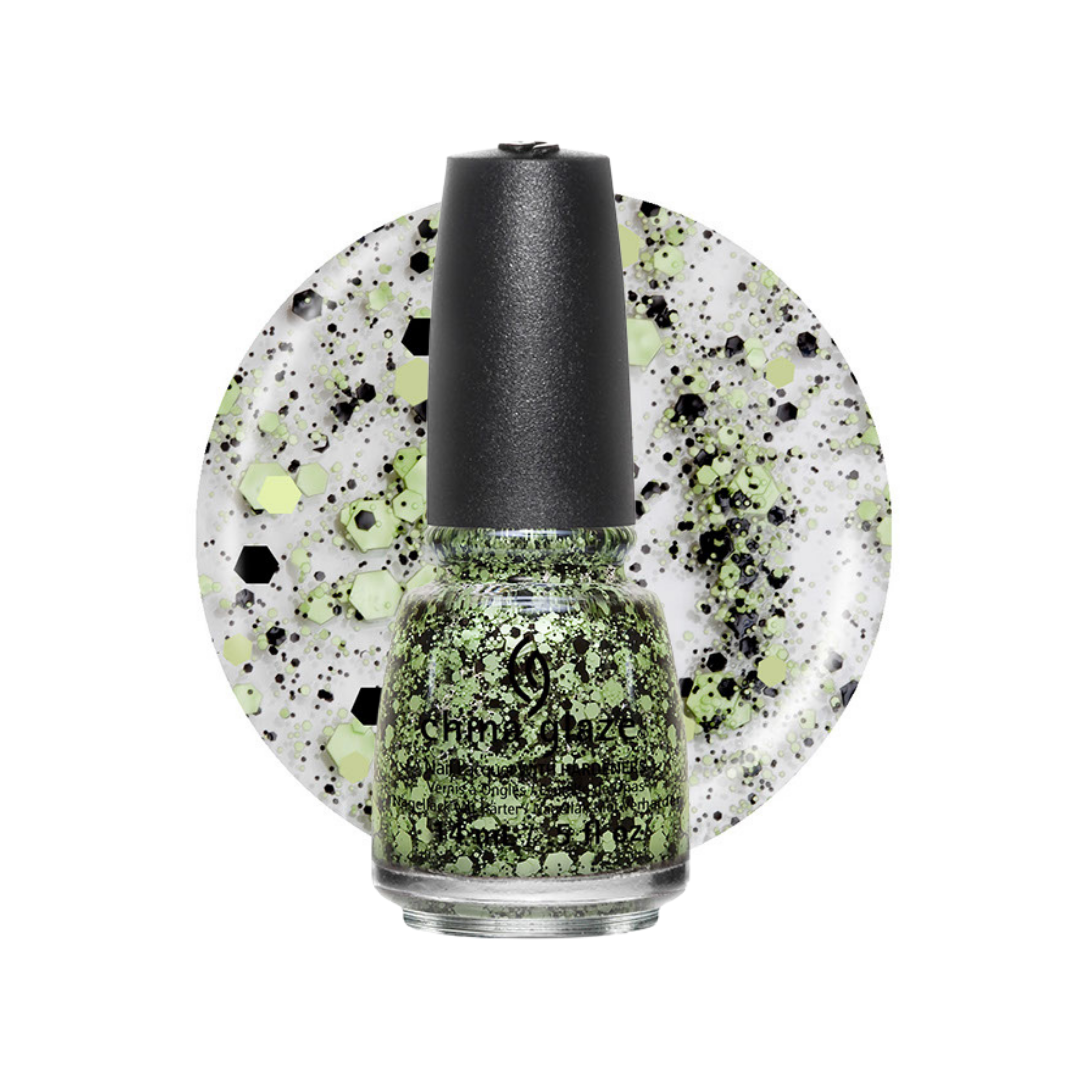 A bottle of China Glaze nail polish with a black cap, filled with shimmering green glitter polish, set against a circular white swatch showing the same green and black speckled pattern.