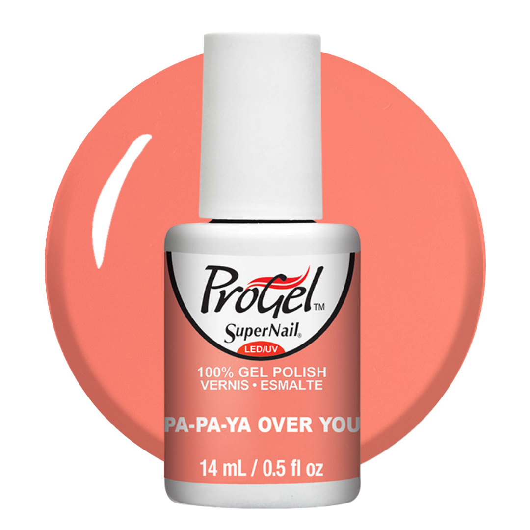 A bottle of ProGel SuperNail LED gel nail polish in the shade 'PA-PA-YA OVER YOU', featuring a white cap and a white label with black and red text, set against a coral pink circular background on a white studio background.