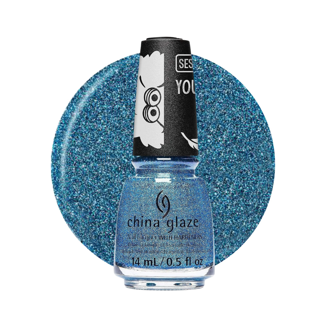 A bottle of China Glaze nail polish in a sparkling light blue shade, shown in front of a large circular blue glitter swatch on a white background. The bottle has a black cap with white cartoon graphics.