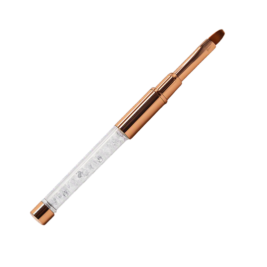 A flat tip gel nail application brush with a clear rhinestone-embellished barrel and rose gold metal ferrule and tip, shown diagonally on a plain white background.
