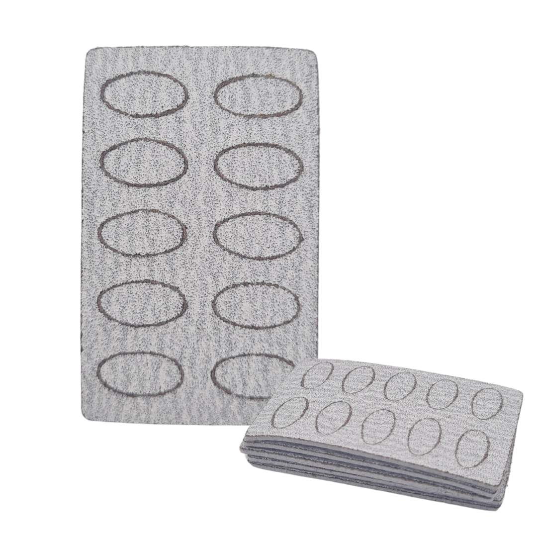 A gray textured grit pad sheet with ten oval cutouts, shown with one grit sheet standing upright and a folded stack of matching grit sheets in front, on a plain white background.