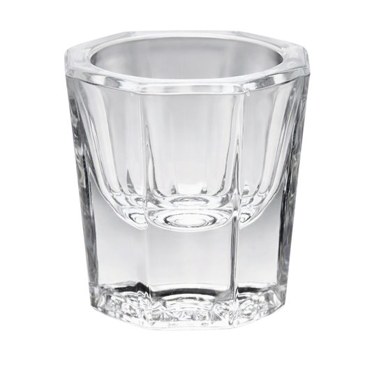 A clear glass Dappen dish used for holding small amounts of acrylic liquid/monomer.