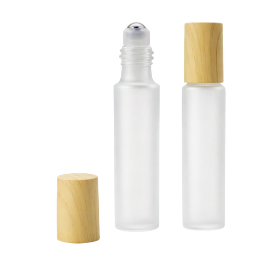 Two frosted glass roller bottles with light natural wood caps, shown on a plain white background. One bottle is upright with its cap off beside it, and two bottles are shown with their caps on.
