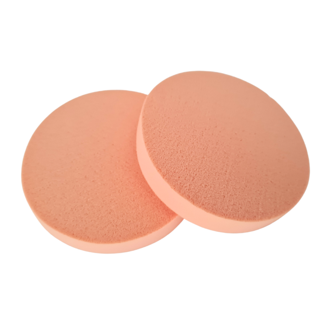 Two round peach-colored makeup sponge applicators overlapping on a plain white background.