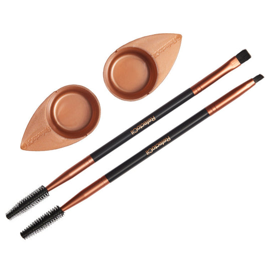 Two brushes with brown handles and brown bristles, two application dishes, and a carrying bag, all laid out on a white background.