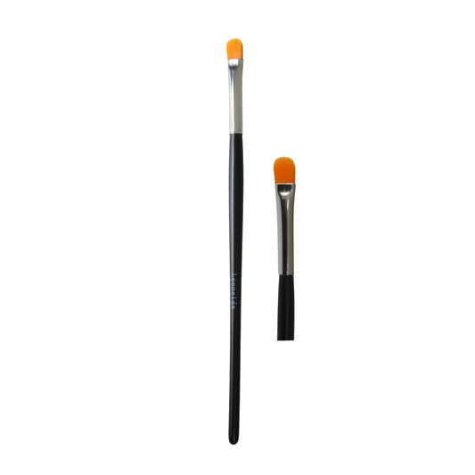 Two eyeshadow and lip makeup brushes with black handles, silver ferrules, and bright orange bristles, shown on a plain white background.