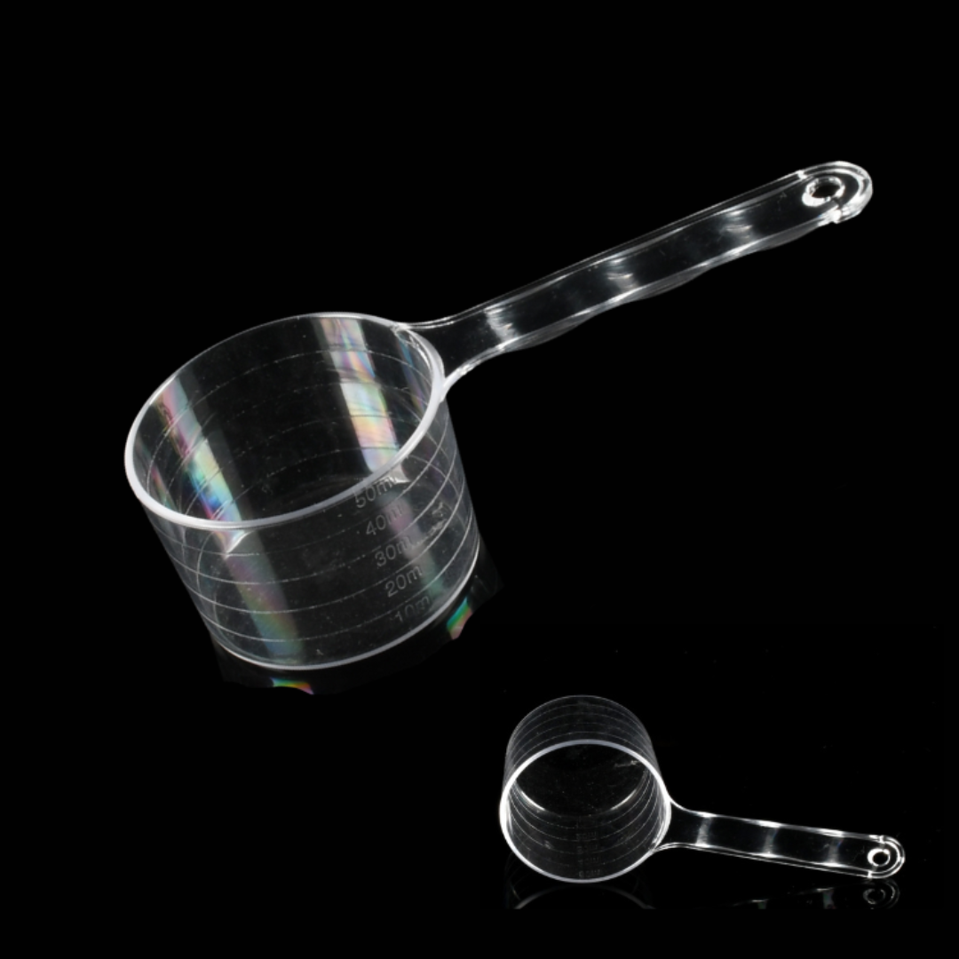 Clear plastic measuring cup with measurement markings and a detachable handle, shown on a black background with a smaller inset view of the handle separated.