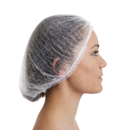 A side profile of a woman wearing a disposable, semi-transparent white hairnet against a solid white background.