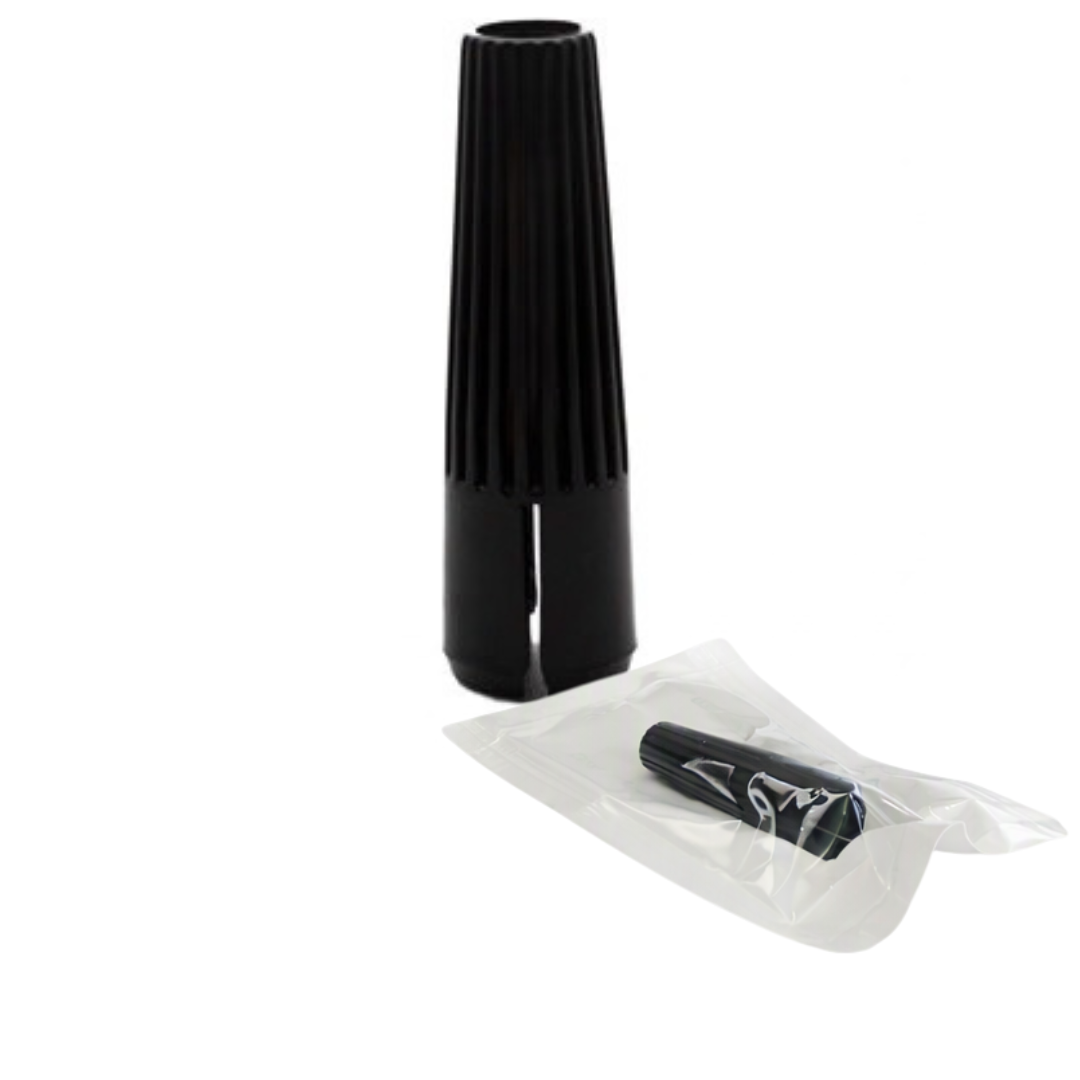 A black plastic permanent makeup needle sleeve standing upright, with a small black one sealed in a clear plastic bag placed in front, on a plain white background.