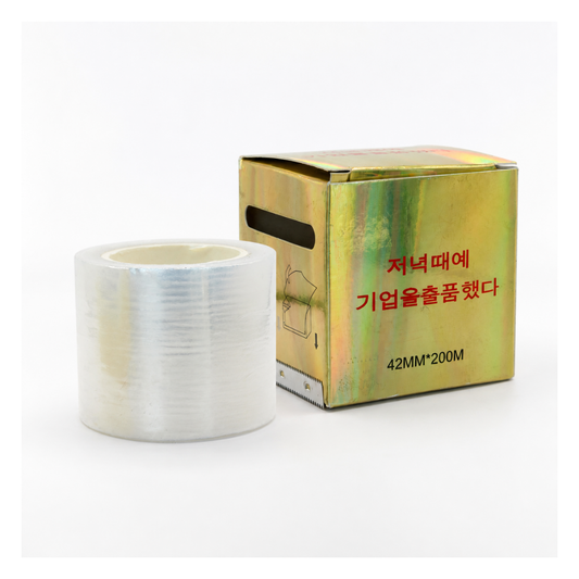 A roll of clear plastic wrap for eyebrow lamination, standing next to its metallic gold cardboard packaging box with red Korean text on a white background.