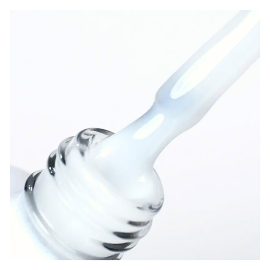 A close-up of a gel nail brush dipping into bottle containing a milky white Leo Laque topcoat, against a clean white background.
