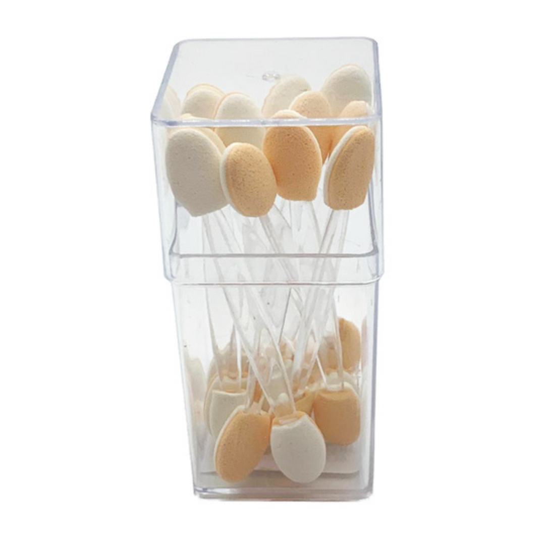 A clear plastic storage container holding multiple small oval sponge applicators on white sticks, shown against a plain white background.
