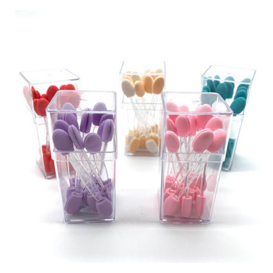 Six small clear plastic containers holding colorful oval-shaped makeup eyeshadow sponge tips in assorted shades including pink, purple, red, beige, and teal, arranged on a white background.