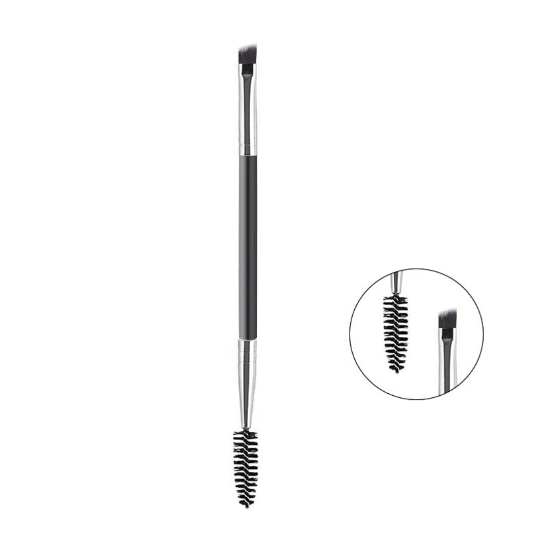 A dual-ended eyebrow grooming brush with a black handle, silver ferrules, and black bristles, shown on a white background with a circular inset highlighting the spoolie and flat tip details.