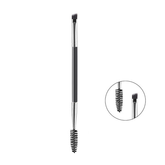 A dual-ended eyebrow grooming brush with a black handle, silver ferrules, and black bristles, shown on a white background with a circular inset highlighting the spoolie and flat tip details.