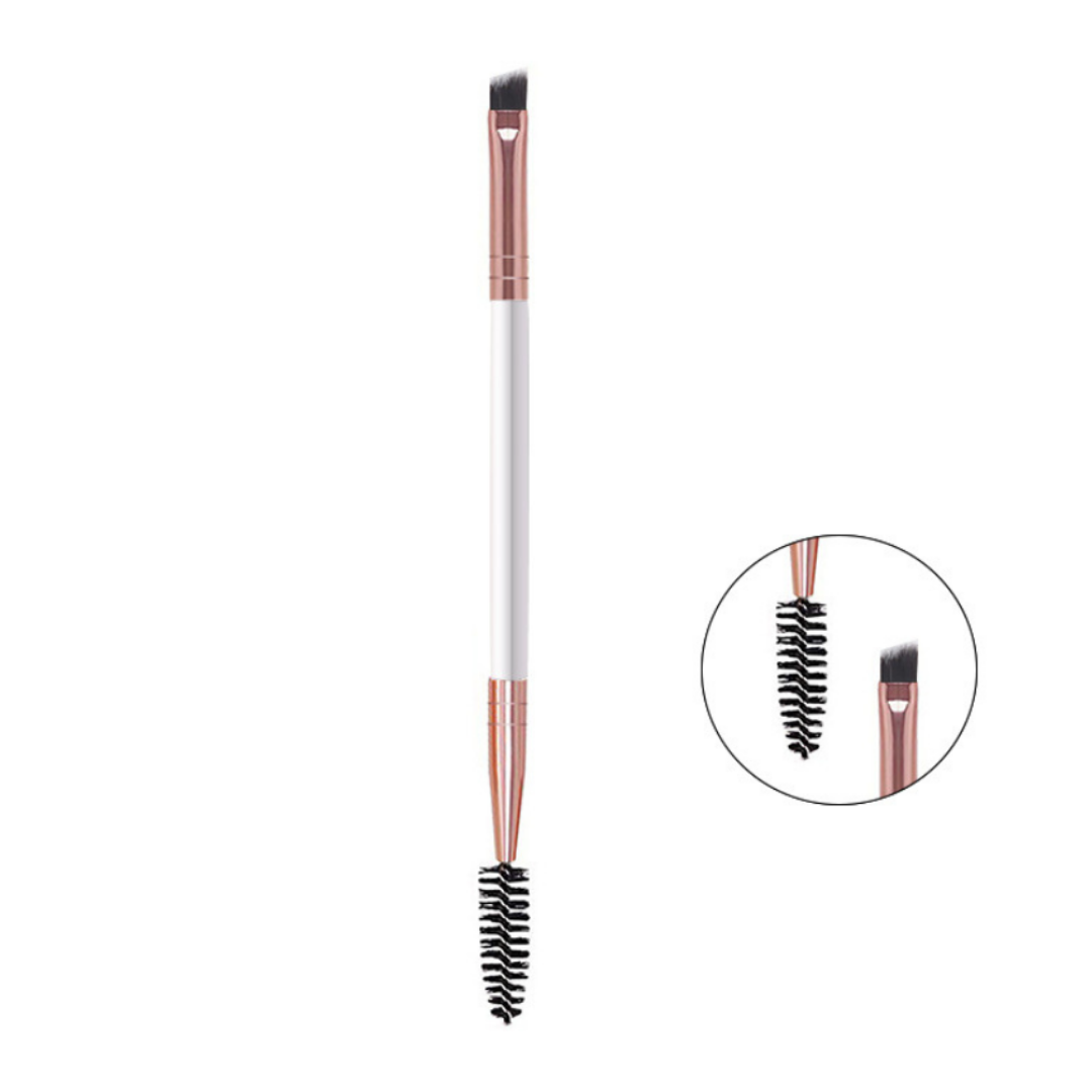 A dual-ended eyebrow grooming brush with a white handle, rose gold metal ferrules, and black bristles, shown on a plain white background with a circular inset detail of the spoolie and flat tip.