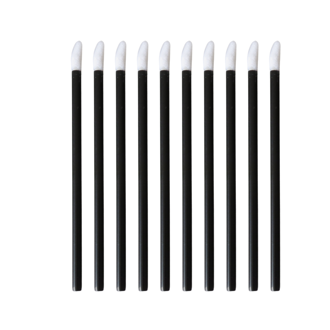 Ten black lip gloss and lipstick applicators with white tips, arranged in a row on a plain white background.