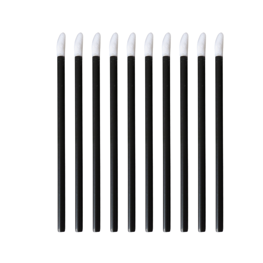 Ten black lip gloss and lipstick applicators with white tips, arranged in a row on a plain white background.