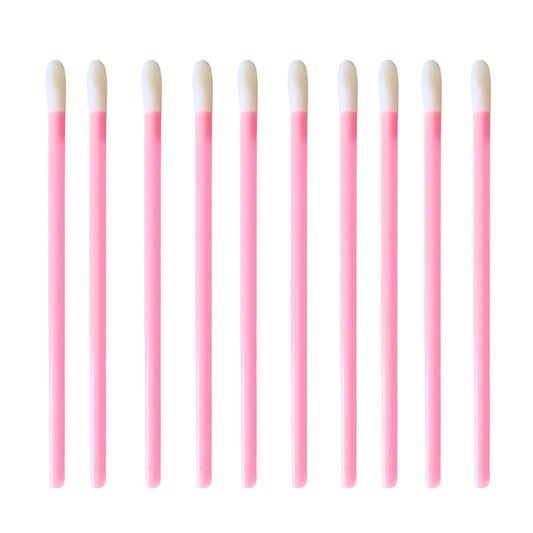 Ten pink lip gloss and lipstick swab sticks with white tips, arranged in a neat horizontal row on a solid white background.