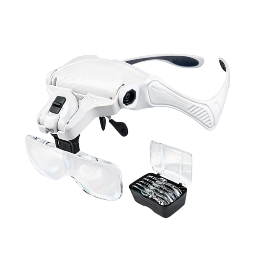 White and black magnifying loupe with attached clear protective eyepieces and a small black storage case containing multiple lens attachments, shown on a plain white background.