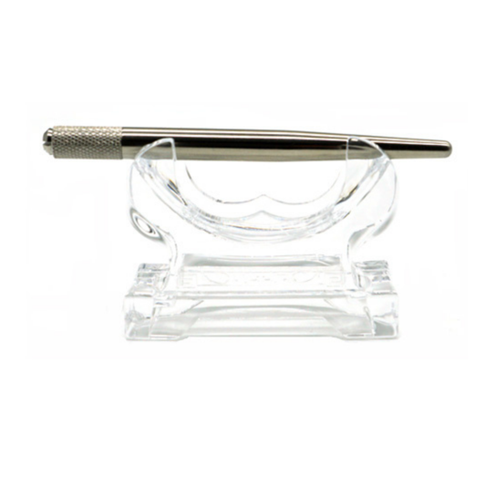 A silver metal microblading tool with a knurled textured handle, resting on a clear acrylic display stand against a white background.