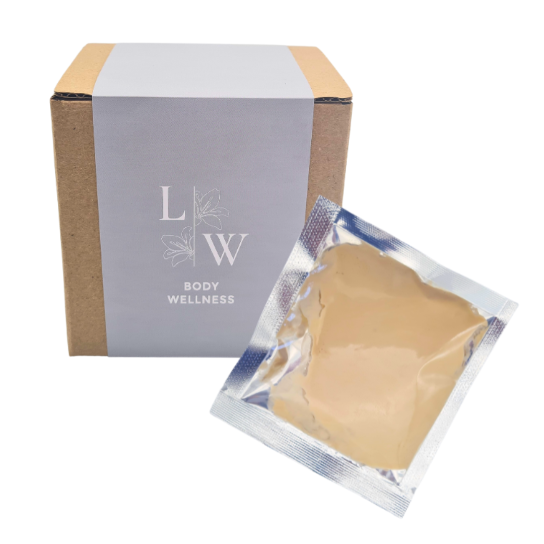 A kraft paper box with a gray paper band labeled 'LW BODY WELLNESS' stands next to an individual silver foil packet containing a beige immune boost mud wrap mask, on a white background.