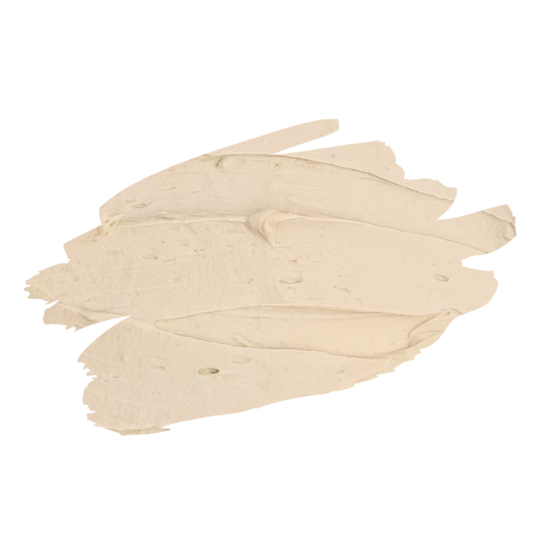 A textured smear of cream-colored chocolate cocoa body mask cream or clay powder on a solid white background.