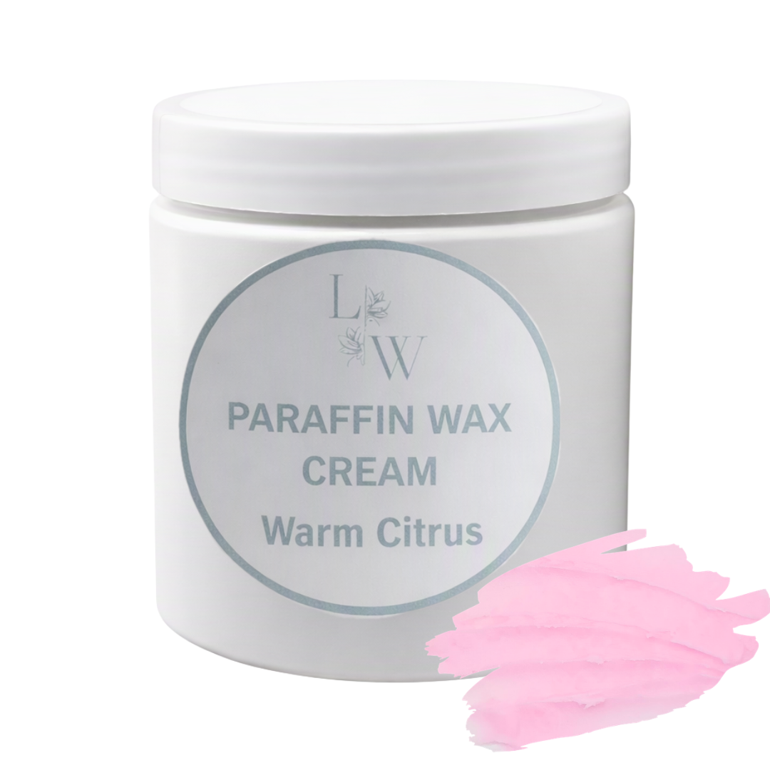A white plastic jar of LW Paraffin Wax Cream in the 'Warm Citrus' scent, shown on a white background with a pink wax smear graphic in the bottom right corner.