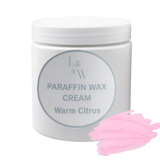 A white plastic jar of LW Paraffin Wax Cream in the 'Warm Citrus' scent, shown on a white background with a pink wax smear graphic in the bottom right corner.