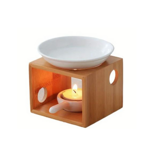 Wooden warmer with a white bowl and a lit candle inside on a white background
