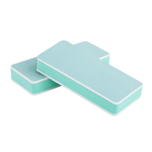 A 2 sided green nail shiner block with a light green surface on one side and a darker green surface on the other, typically used for shining and smoothing nails.