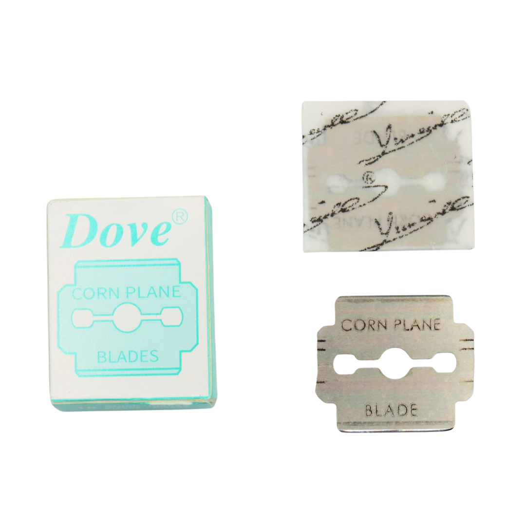 Dove Callus Plane Blades shown with their retail box on a plain white background. The set includes a silver metal blade and a translucent protective film sleeve with printed brand markings.