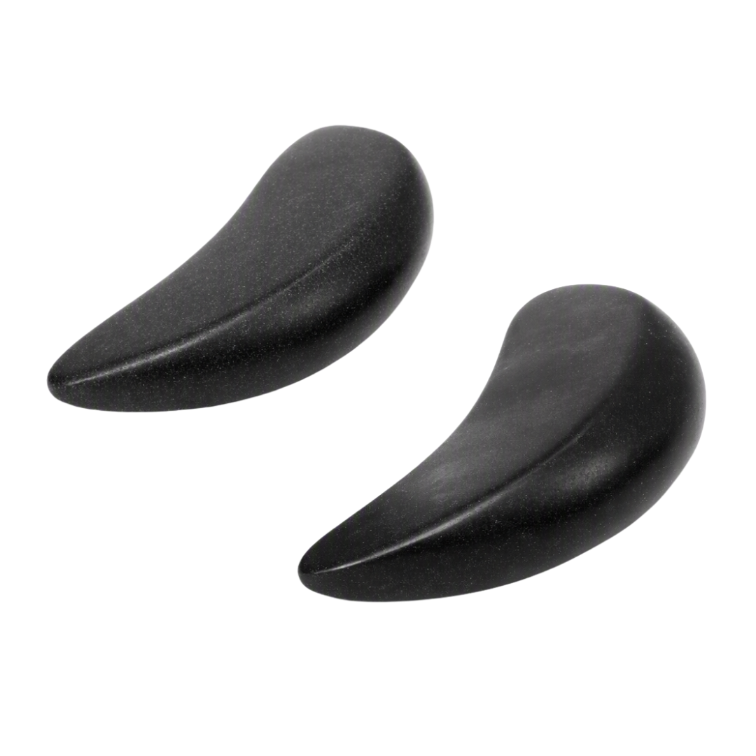 Two black crescent-shaped basalt massage stones shown side by side on a plain white background.