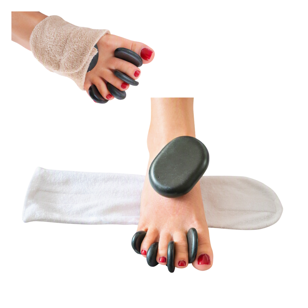 Pedicure spa set featuring black heated stones, a white towel, and a beige wrist wrap, shown being used on a foot and wrist against a white background.