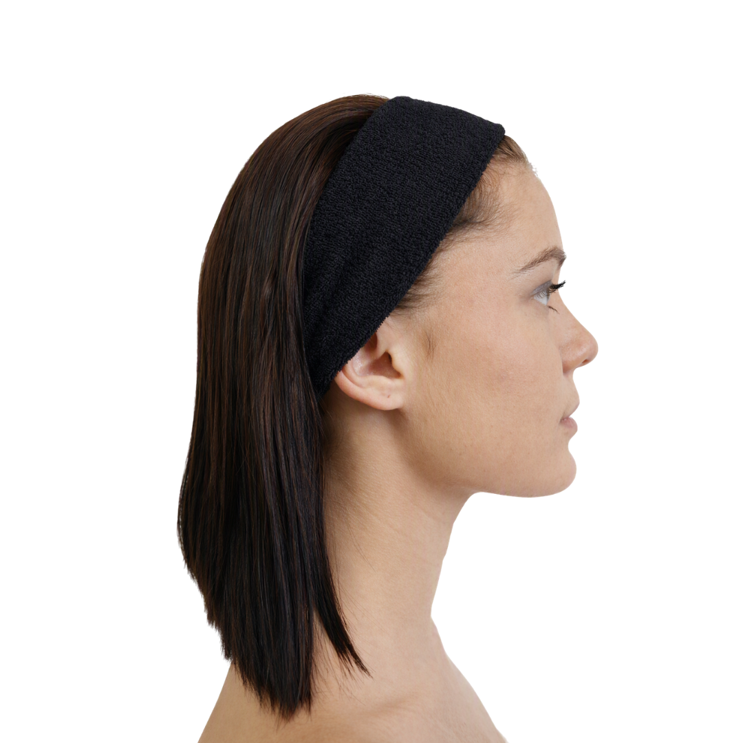 A woman shown in side profile wearing a wide, textured black headband against a plain white background.