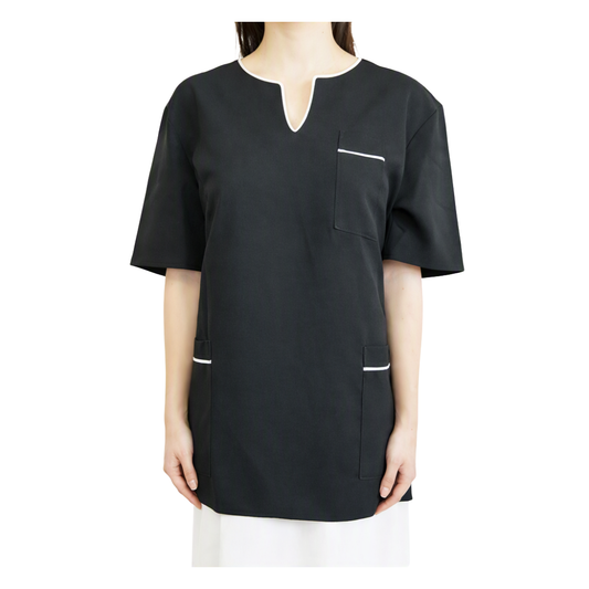 A black short-sleeve scrub top with a split neckline, a chest pocket with white piping, and two lower patch pockets with white piping, shown on a model against a white background.