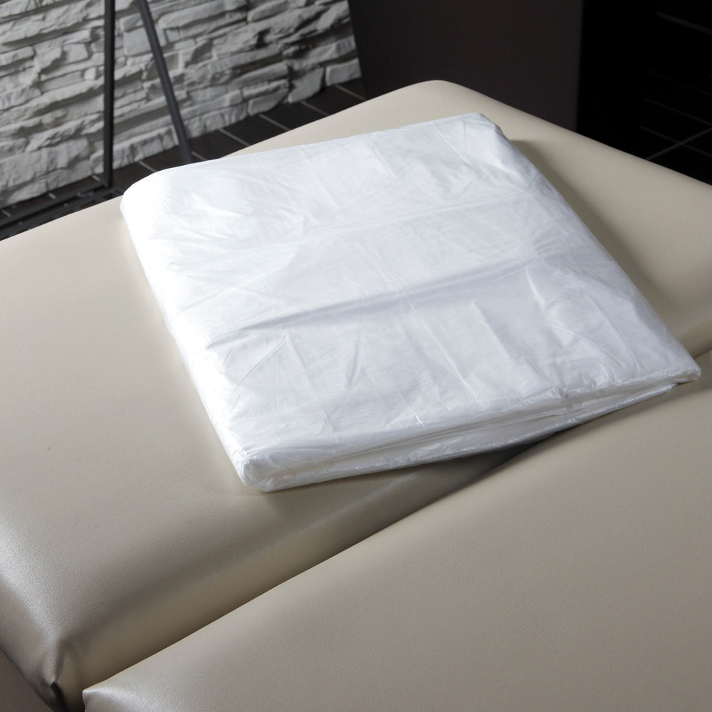 Z708F Plastic Polyethylene Body Wrap Sheets 50piece | Folded clear plastic sheets for body wraps on a beige bed