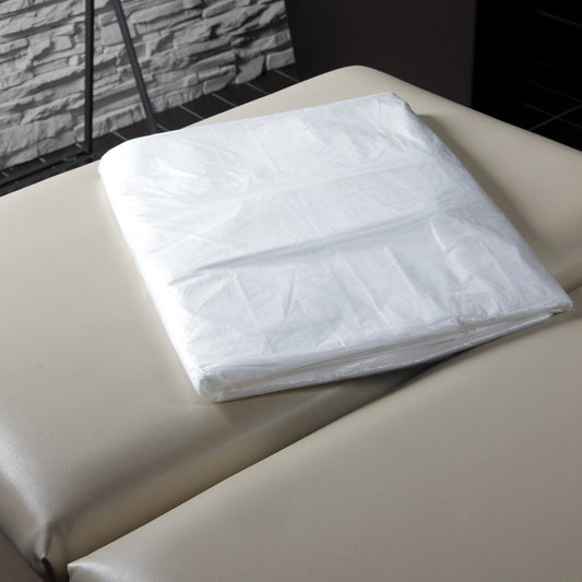 Z708F Plastic Polyethylene Body Wrap Sheets 50piece | Folded clear plastic sheets for body wraps on a beige bed