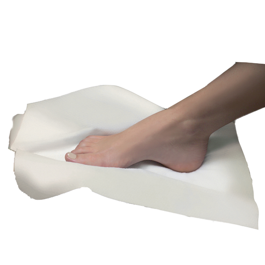 Z711A Dry Paper Towel for Manicure and Pedicure | A close-up of a person's foot pressing down on a white, paper dry disposable towel to demonstrate its softness and comfort.