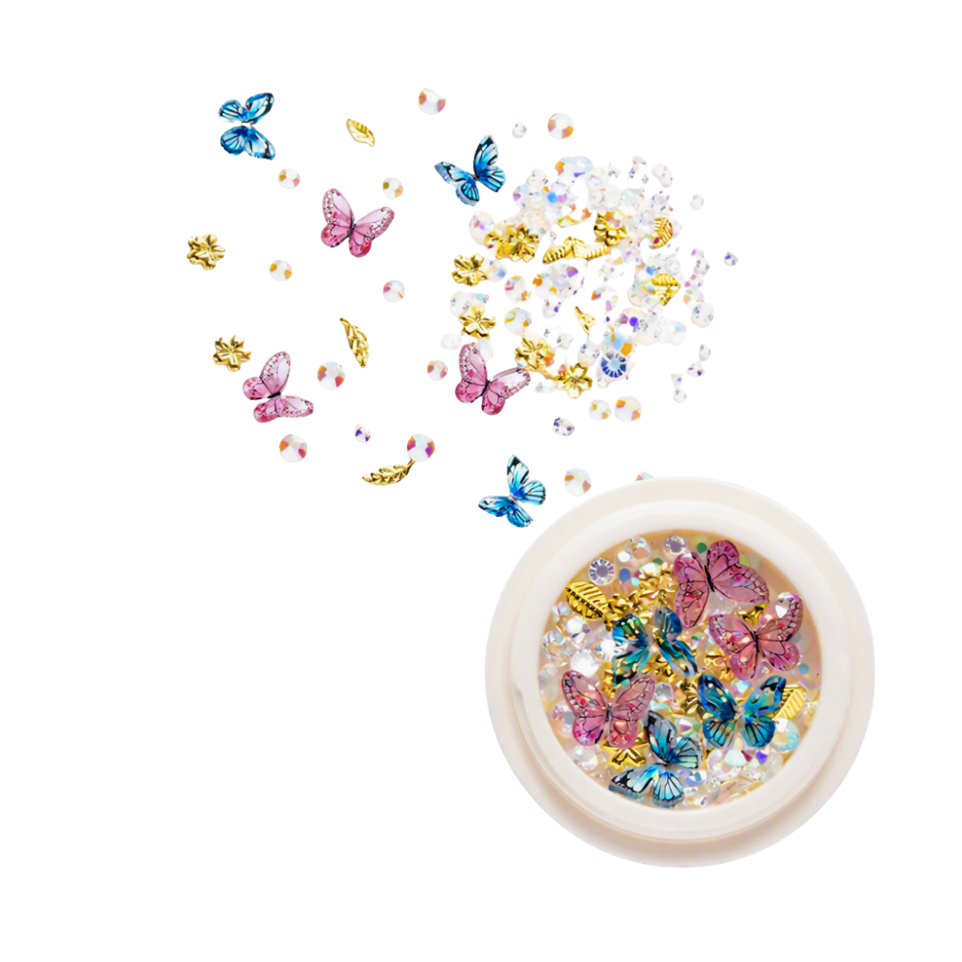 A round pot of 3D nail art rhinestones, gems and butterflies with loose ones in the background