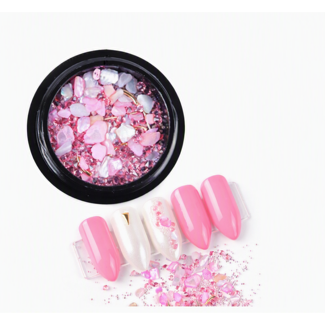 Shades of Pink micro zirconium shell stones for nail art in black round container with examples of nail art in foreground 