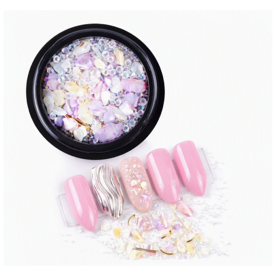 Clear and Shades of Pink micro zirconium shell stones for nail art in black round container with examples of nail art in foreground 