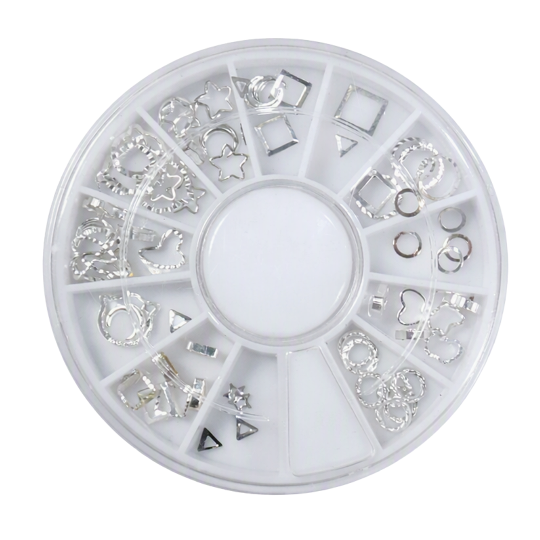 A circular white plastic compartment wheel containing multiple small silver-tone metal nail art charms and embellishments, photographed on a plain white background.