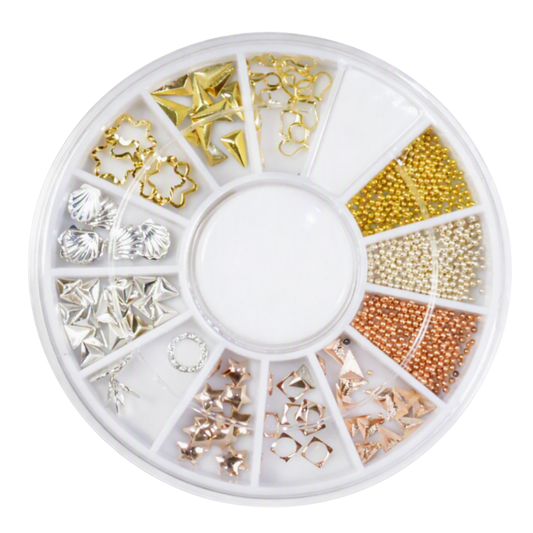 A circular white plastic compartment organizer filled with assorted decorative nail art pieces, including star, triangle, shell, and bead styles in gold, silver, champagne, and rose gold tones, on a plain white background.