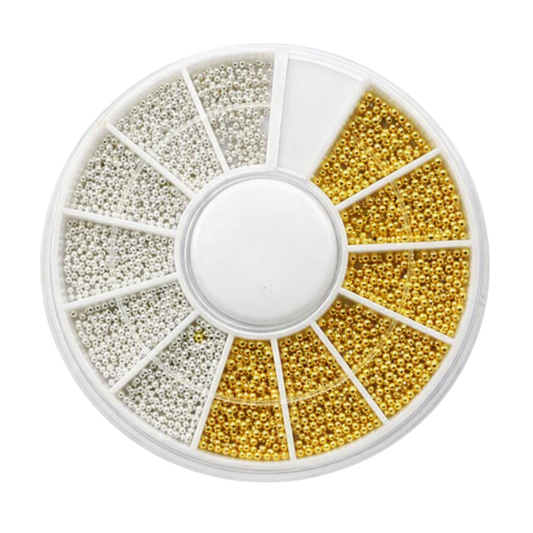 A circular white plastic compartment organizer filled with assorted decorative nail art pieces, including round silver and gold bead styles in gold, silver, on a plain white background