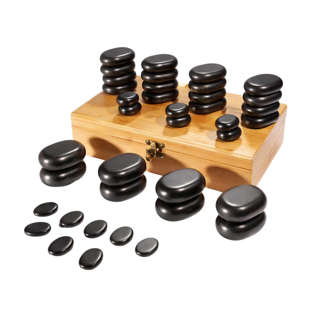 A set of smooth, black basalt stones of various sizes, displayed both stacked and spread out on a light wooden surface with a bamboo case.