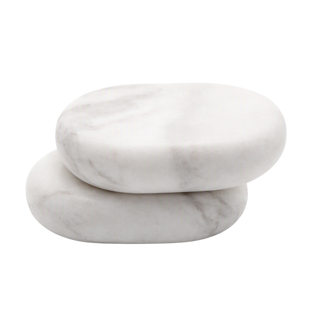 Two smooth oval cold massage stones stacked on top of each other, made from white marble with soft gray veining, set against a solid white background.